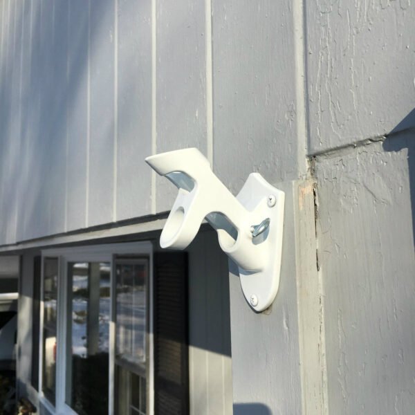 White Cast Aluminum 2 position flag pole Bracket mounted on home. Side view. Made in U.S.A.