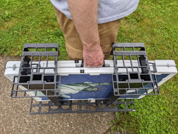 Caddy hangs on cornhole set for easy carrying